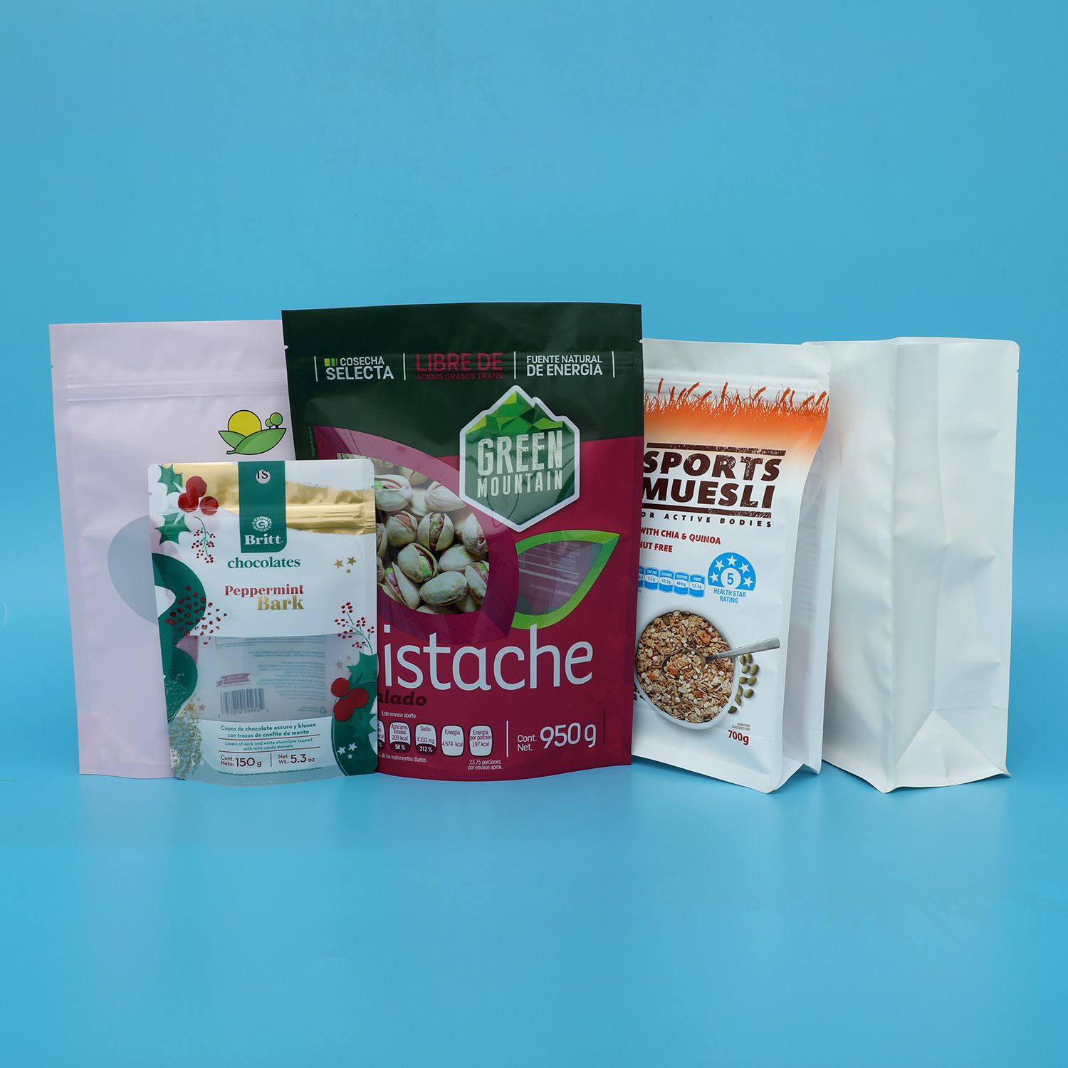 Packaging sample photo — stand-up and flat-bottom pouches for nuts, chocolate and muesli. Brand artwork belongs to its owners and is shown only as a format example. Not a customer project or endorsement.